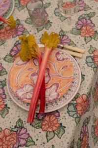 Floral table cloth decorated with tableware. 